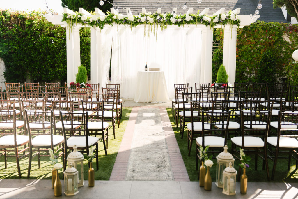 The Ultimate Wedding Guide For Five Crowns In Corona Del Mar. Wedding ceremony venue with wedding arch and rows of chairs.