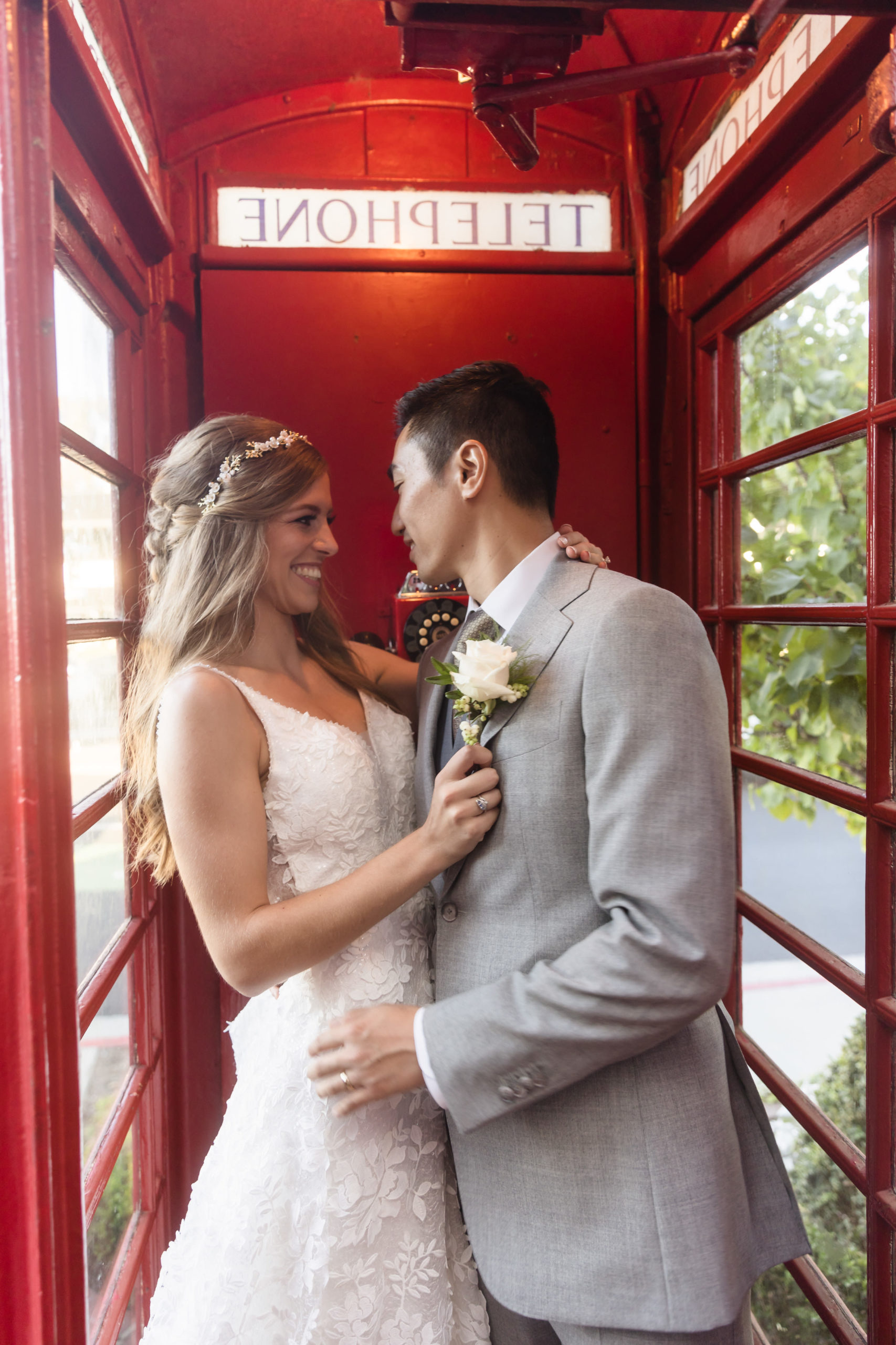 The Ultimate Wedding Guide For Five Crowns In Corona Del Mar. Couple posing inside red telephone booth.
