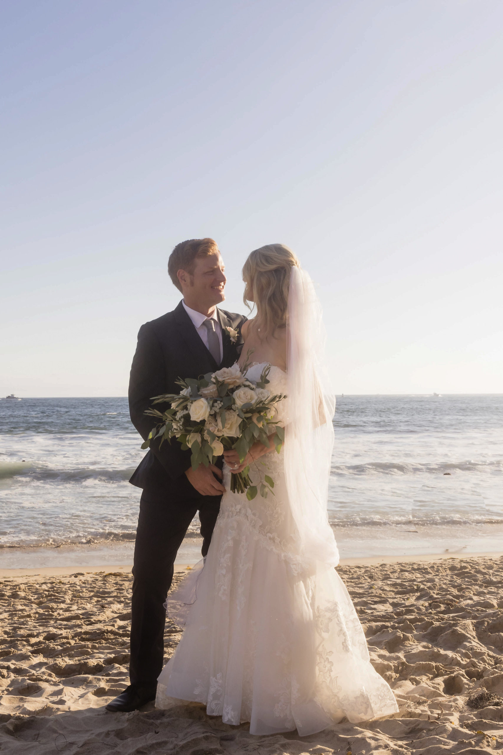 Bride and groom posing with each other at the beach, captured by Christopher Brown weddings