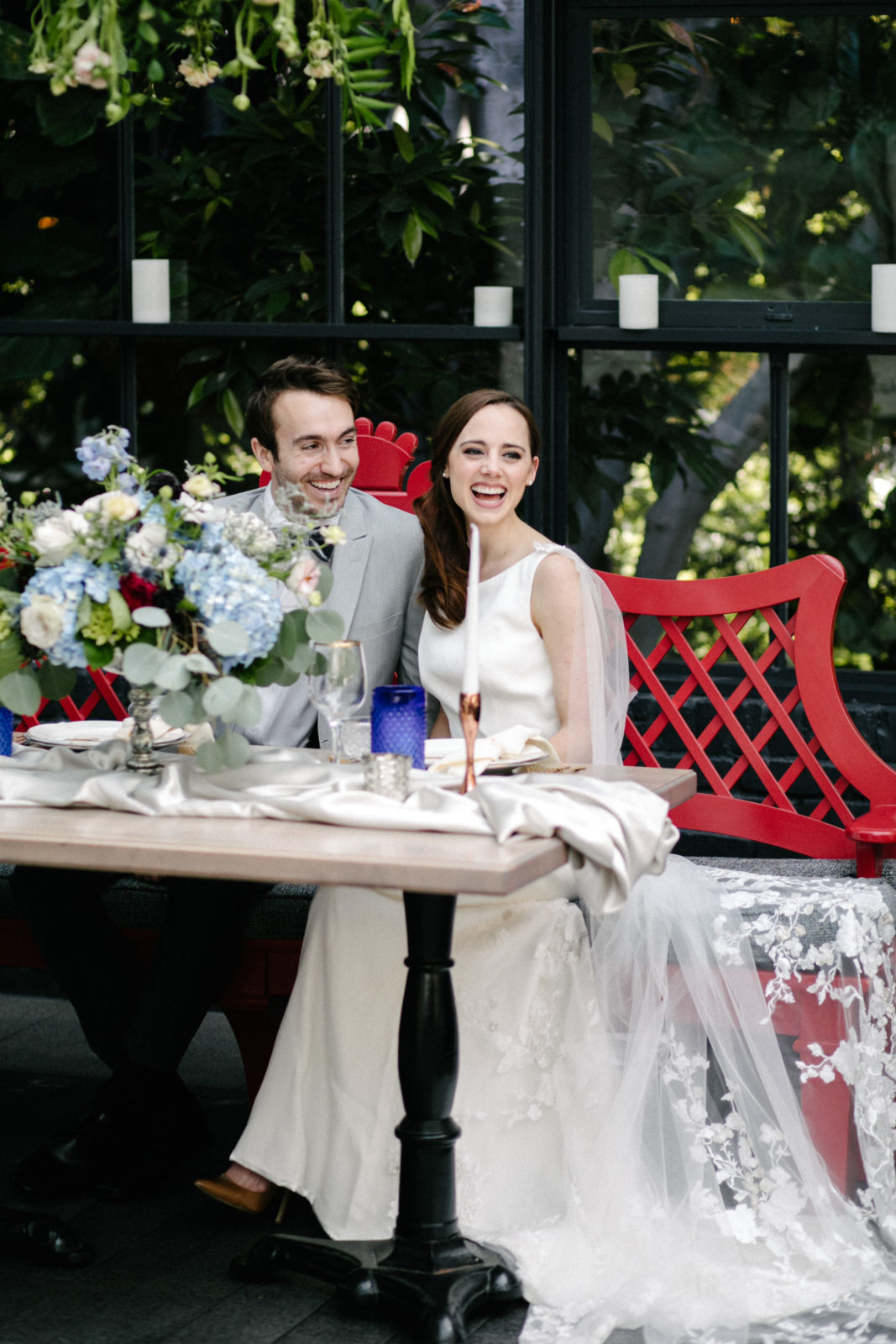 Couple candidly smiling during their wedding reception at the sunlit greenhouse at Five Crowns in Corona del Mar