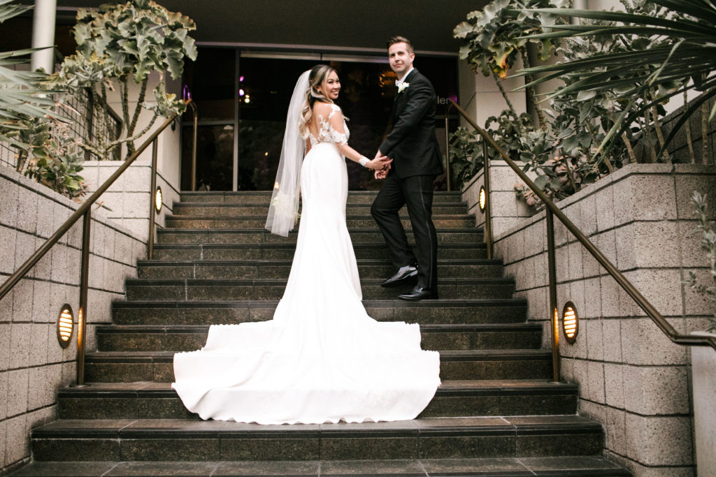Seven Degrees Laguna Beach Wedding: Complete Planning Guide. Bride and groom posing in the middle of the stairs.