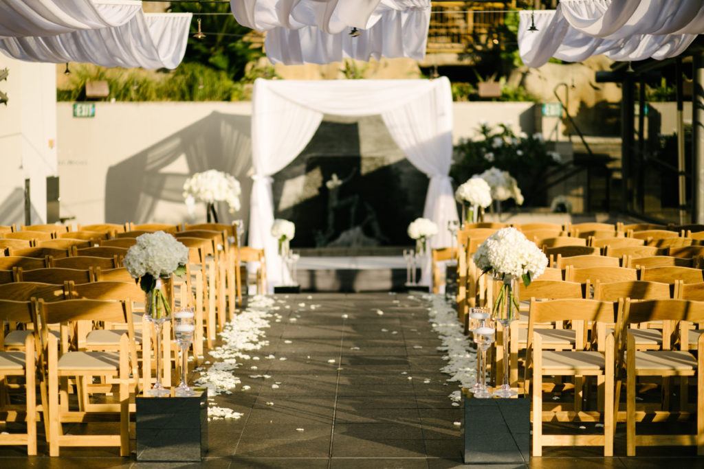 Seven Degrees Laguna Beach Wedding: Complete Planning Guide. Wedding ceremony setup with floral arrangements and wedding arch.