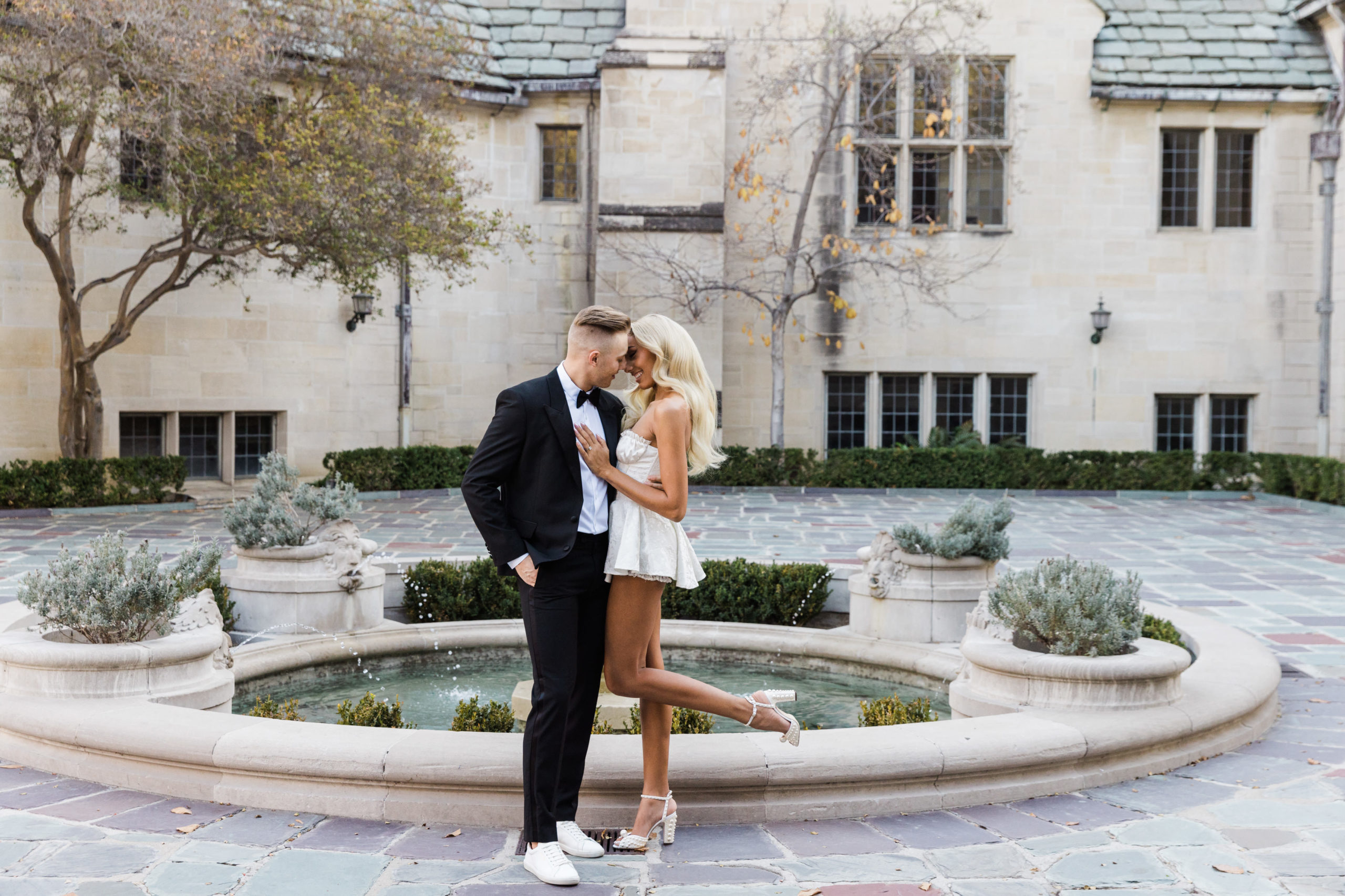 Engaged couple sharing an embrace in front of the fountain at Greystone Mansion, captured by Christopher Brown Weddings