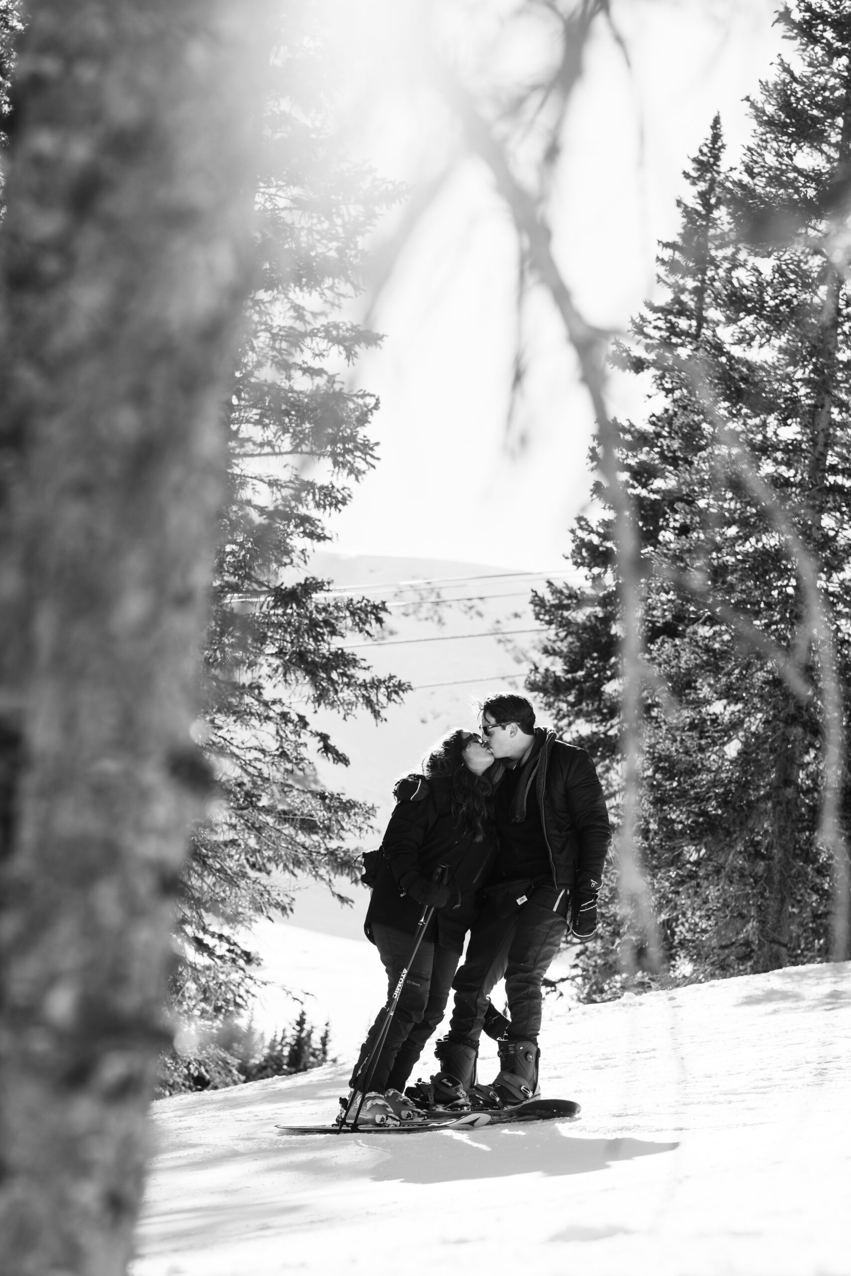 Black and white photo of couple sharing a kiss during their ski trip, taken by Christopher Brown Weddings