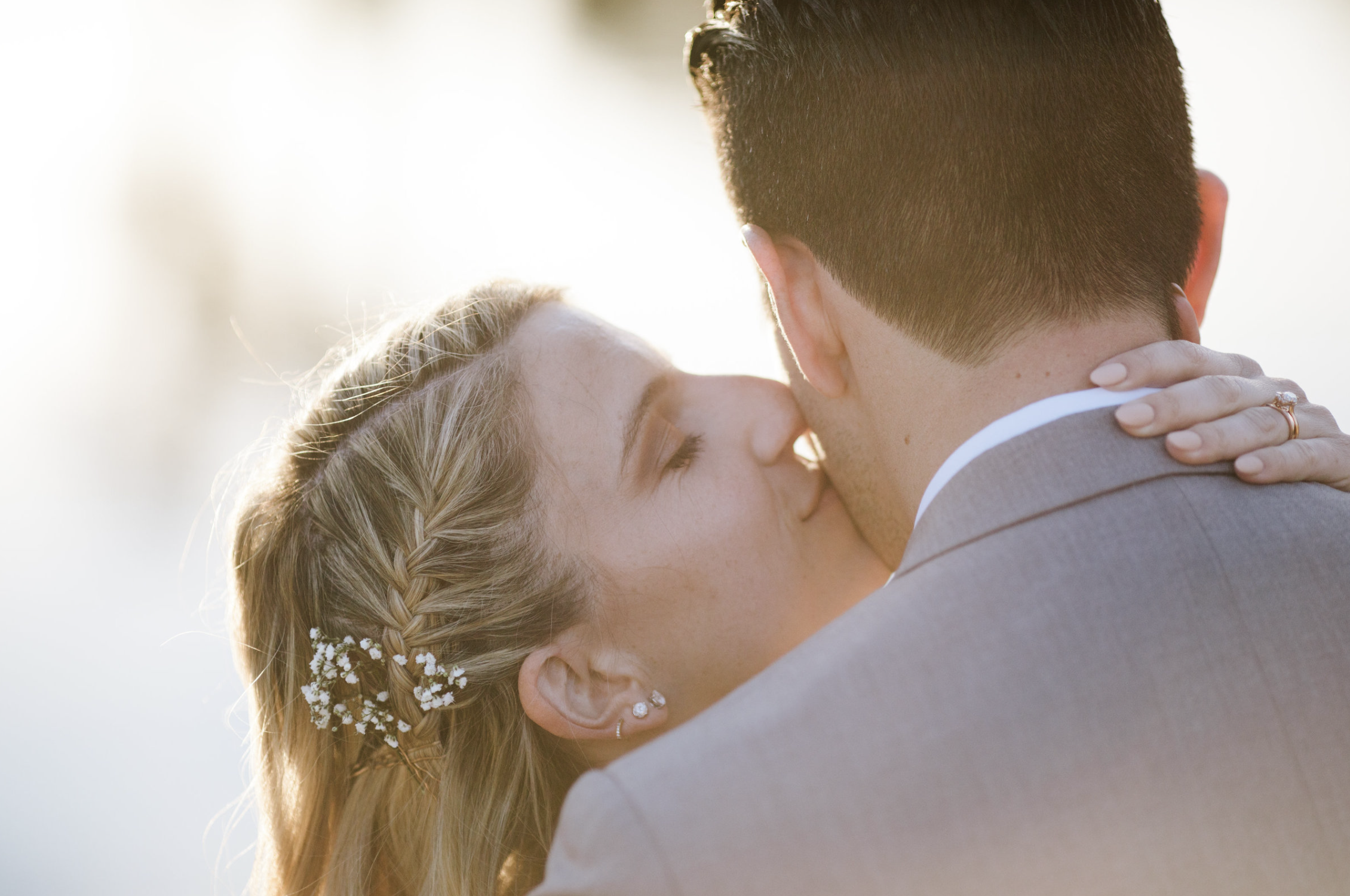 Close-up shot of bride kissing groom on the cheek, captured by Christopher Brown Weddings