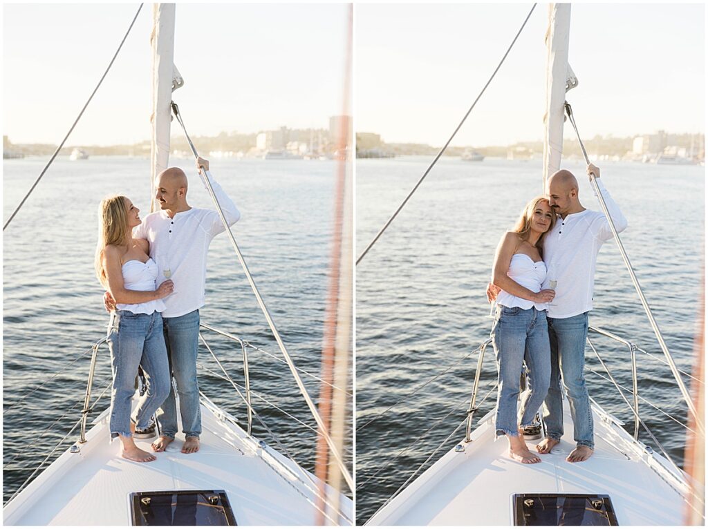 Couple wearing white tops and jeans standing on the edge of a sailboat in Newport Beach harbor