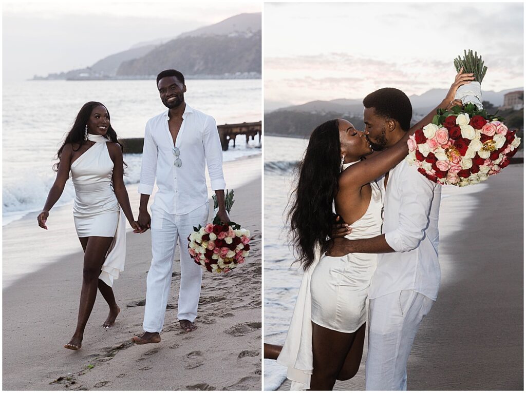 Couple walking along the beach and carrying a large bouquet of white, pink and red roses.