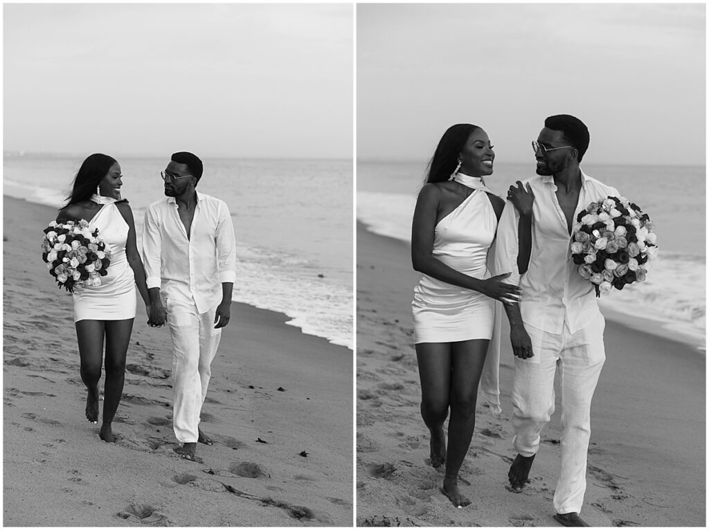 Couple walking along the beach and carrying a large bouquet of white, pink and red roses.