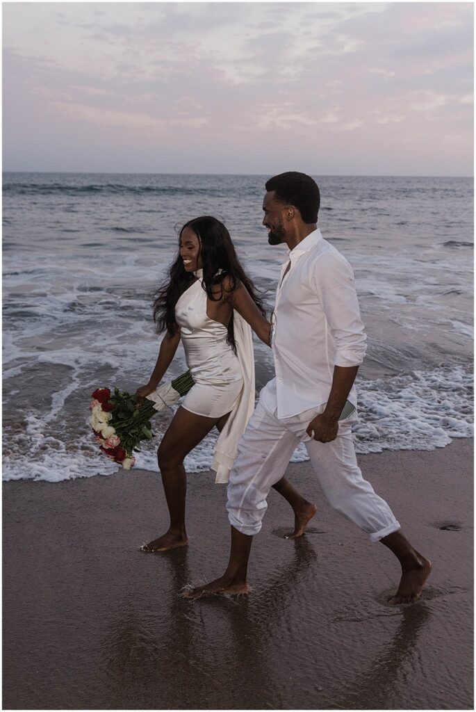 Couple walking along beach at malibu engagement session at Will Rogers State beach