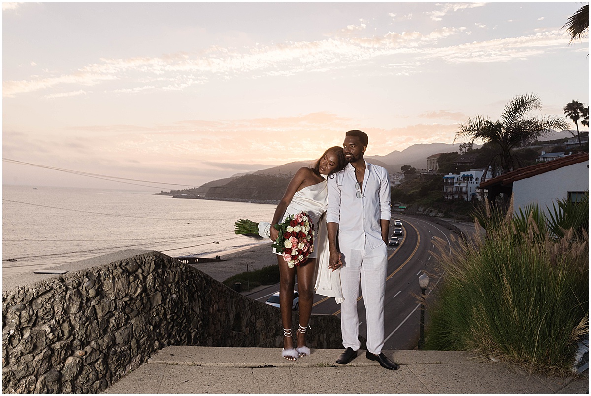 Couple standing on steps above the Pacific Coast Highway in Malibu for Malibu engagement session