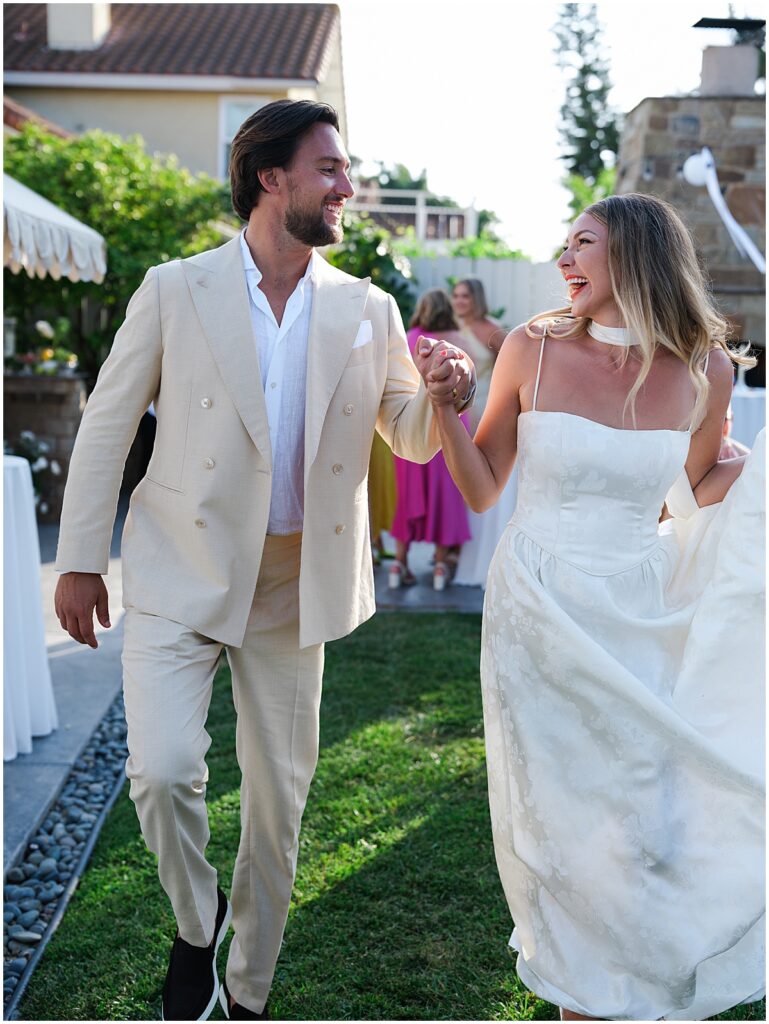 Bride and groom looking at each other and smiling at Carlsbad backyard wedding