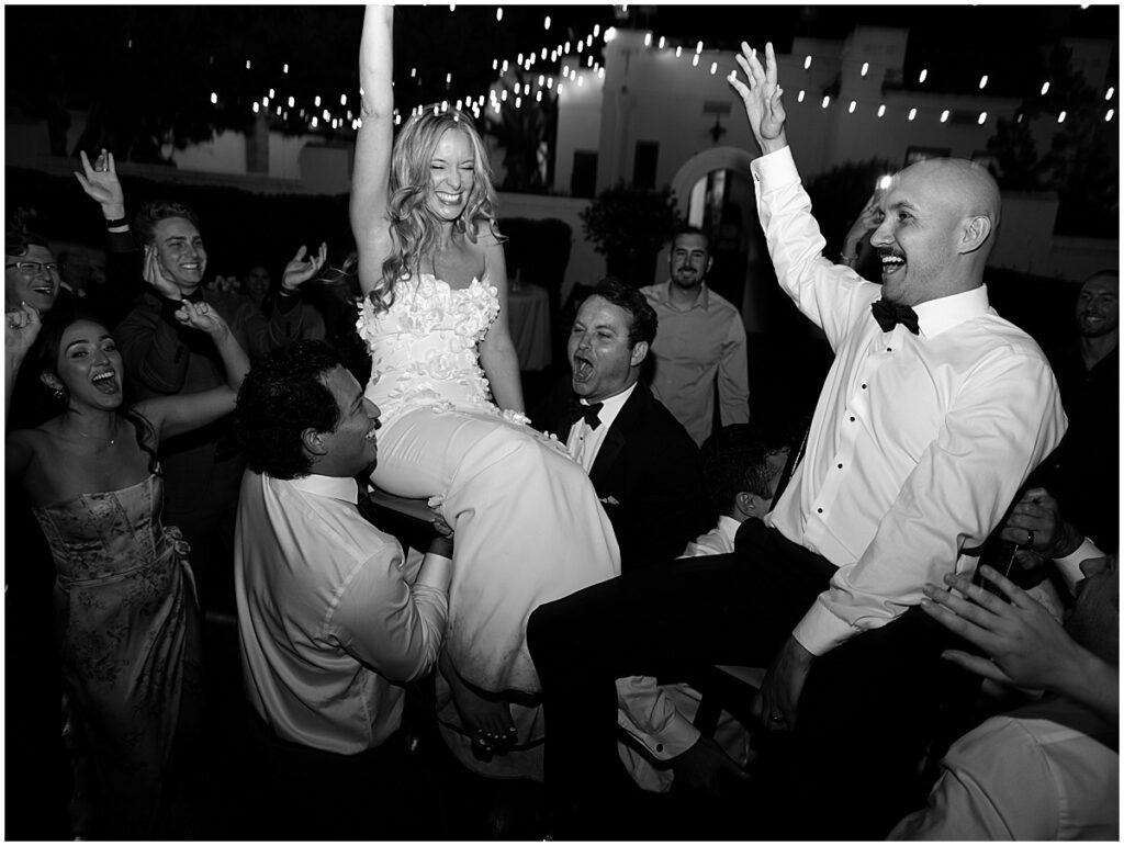 Bride and groom being held up by wedding guests at Muckenthaler Mansion wedding