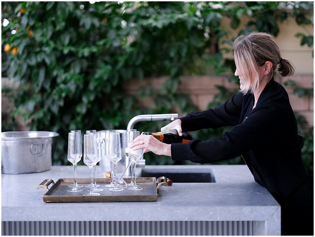 woman pouring champagne for toasts after an engagement at Laguna beach