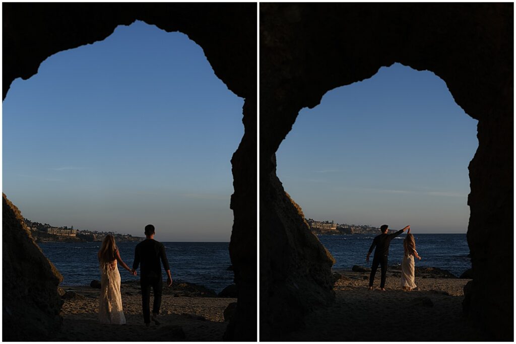 View through the sea caves at Laguna beach at couple wearing black and white outfits for engagement photos