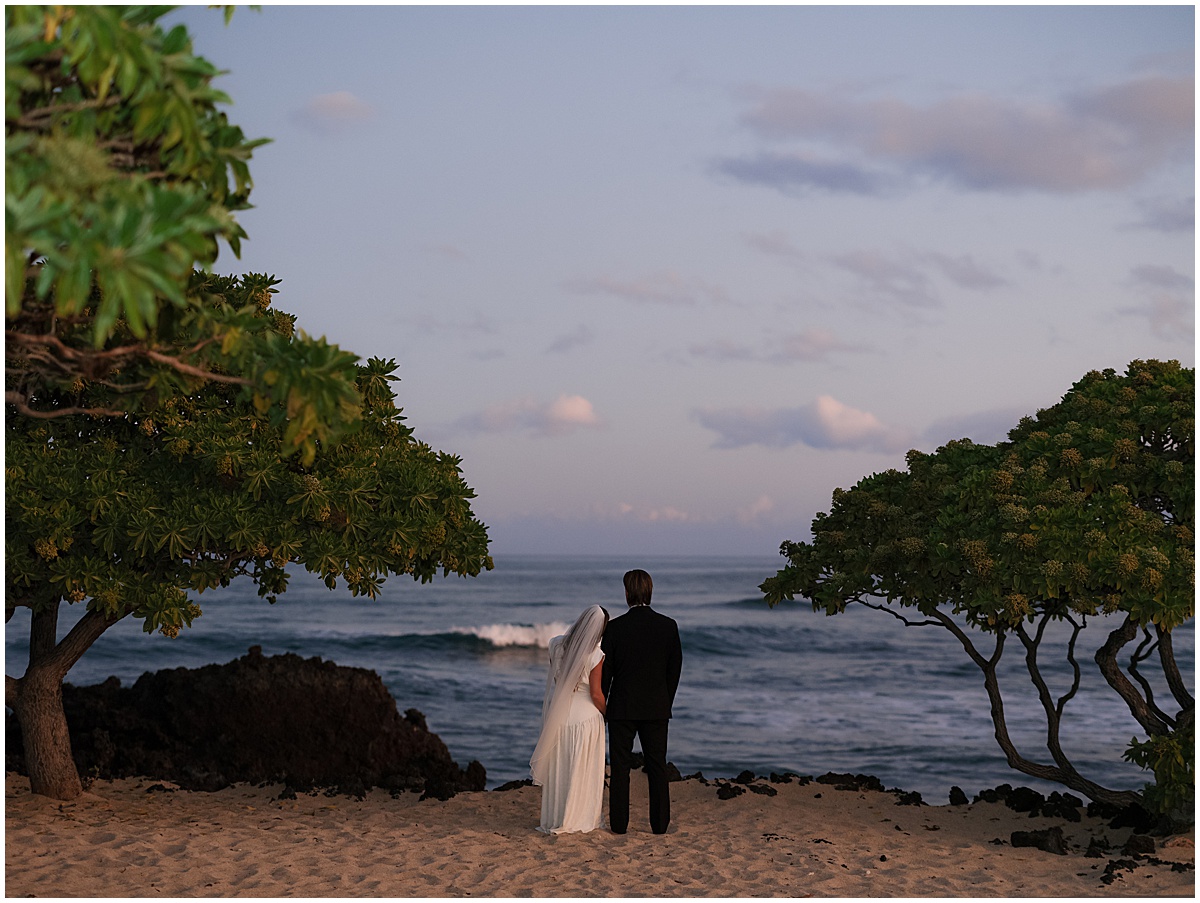 Bride and groom looking out to sea at Four Seasons Hualalai