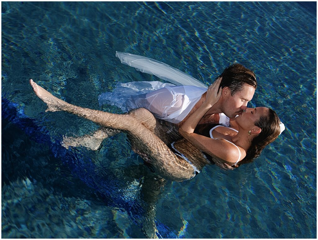 Man kissing woman in the water at Four Seasons Hualalai