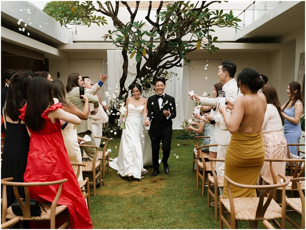Bride and groom walking back down the aisle after their wedding ceremony in Bali