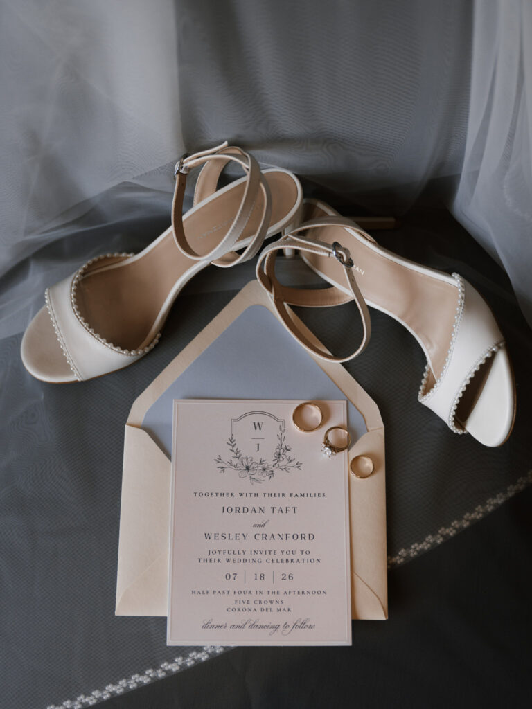 Bridal shoes, wedding invitation, and rings styled together, flat lay detail shot